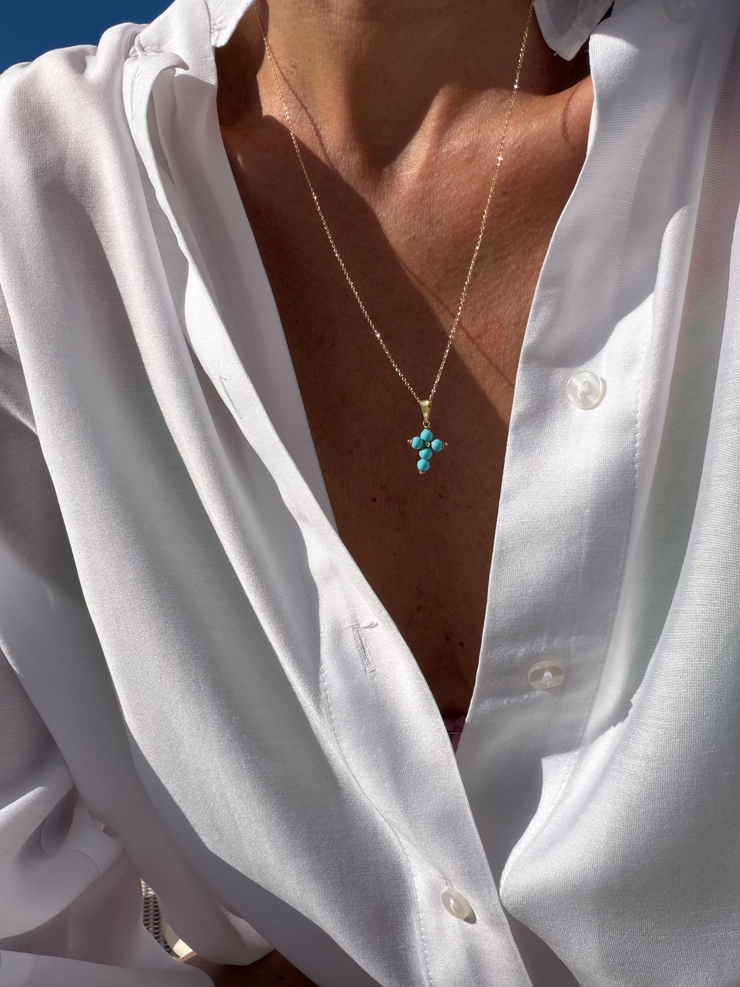 Turquoise cross on a gold chain