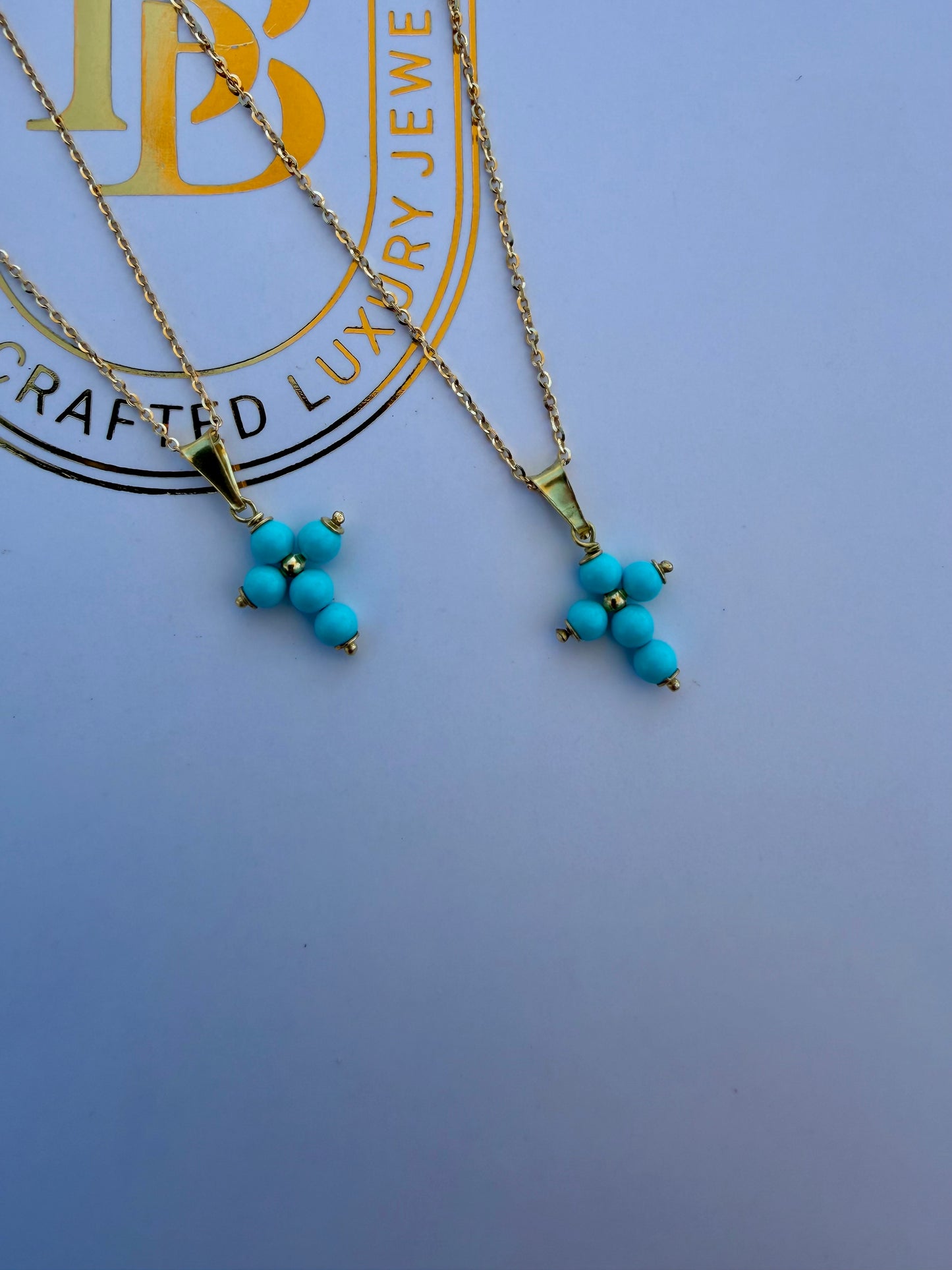 Turquoise cross on a gold chain