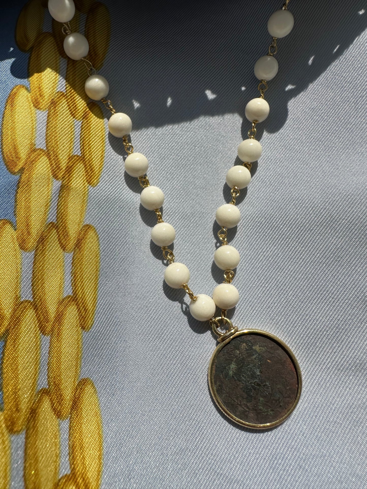 Collana di osso con moneta