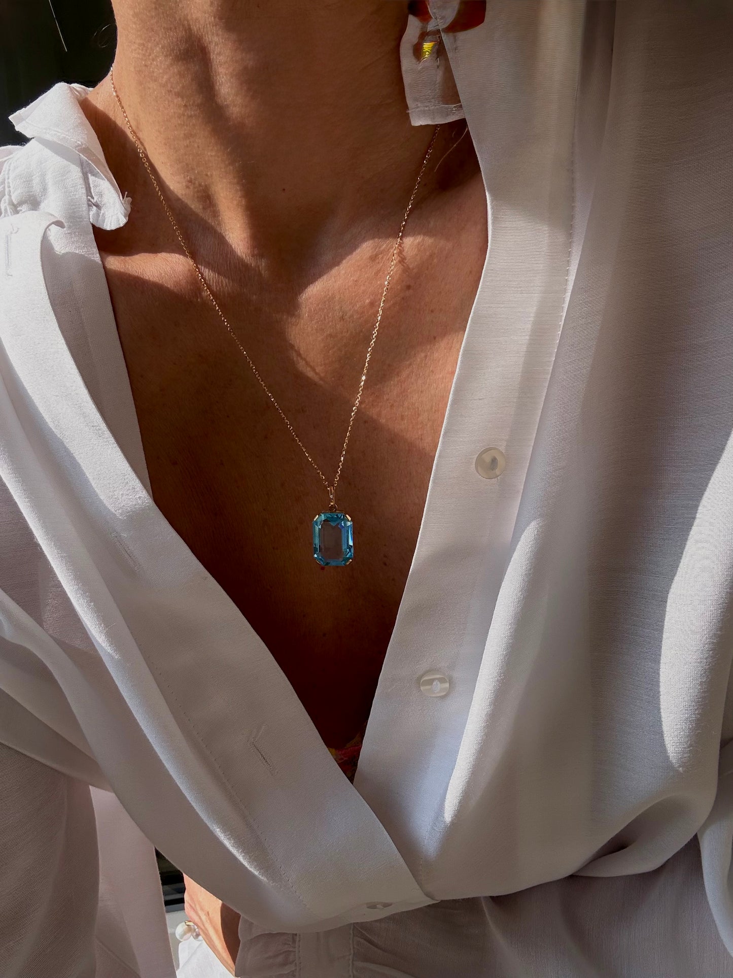 Кулон с голубым топазом изумрудной огранки.